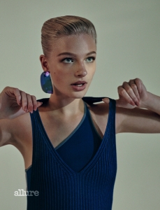 Fashion feature, blue, sport-inspired, room, model, short sleek hair, thick lashes, wears earring, ribbed dress, v-neck, asymmetric top